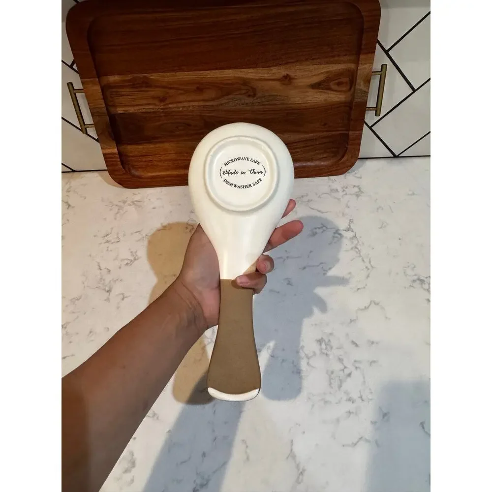 white ceramic spoon rest black bee graphic contrasting brown dipped handle